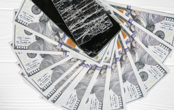 istock Broken screen protector tempered glass. Money lying near the phone. Dollar notes. 1164309150