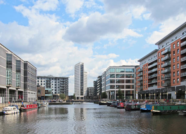 a view of of leeds dock with modern apartment developments and bars with moored houseboats and blue cloudy sky - leeds england yorkshire canal museum imagens e fotografias de stock