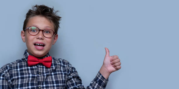 istock Young boy giving thumbs up portrait on violet background 1164316422