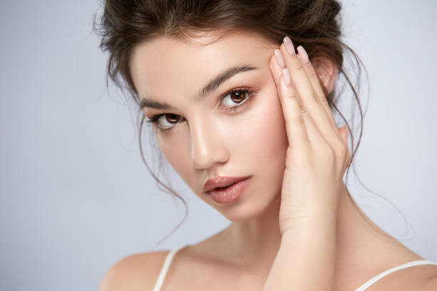istock brunette with big eyes and sexy lips touching her temple anf looking to camera 1164316534