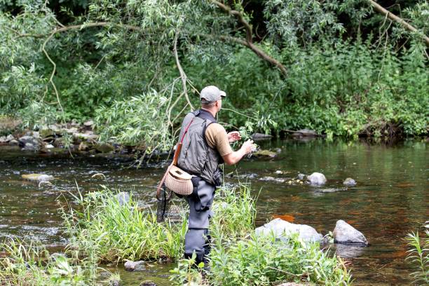 Fisherman standing in the river with spin rod