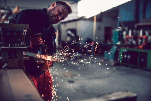 istock Sparks Flying In Factory From Male Worker Using Chainsaw 1164319755