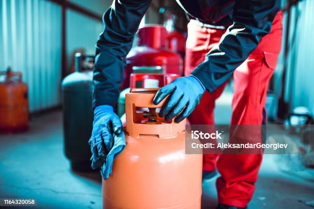Male Worker Cleaning Gas Cylinder In Storage Stock Photo - Download Image Now - Natural Gas, Gasoline, Cylinder