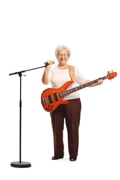 istock Elderly lady with a bass guitar holding a microphone 1164321503