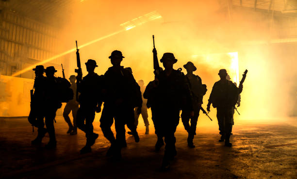 istock Silhouette Army Soldiers Walking In Illuminated Built Structure 1164322863