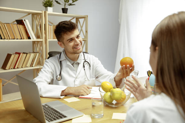 istock Smiling nutritionist showing a healthy diet plan to patient 1164323121