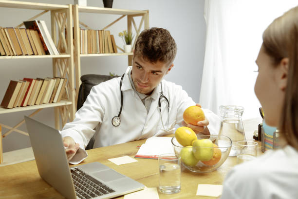 istock Smiling nutritionist showing a healthy diet plan to patient 1164323122