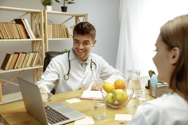 istock Smiling nutritionist showing a healthy diet plan to patient 1164323134