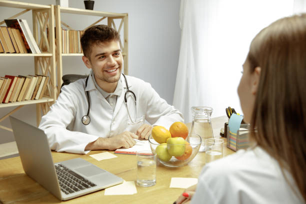 istock Smiling nutritionist showing a healthy diet plan to patient 1164323174