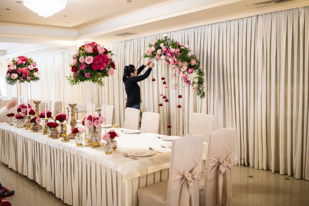 rear view of woman arranging floral decorations for wedding ceremony - flower arrangement dining room decor dining imagens e fotografias de stock