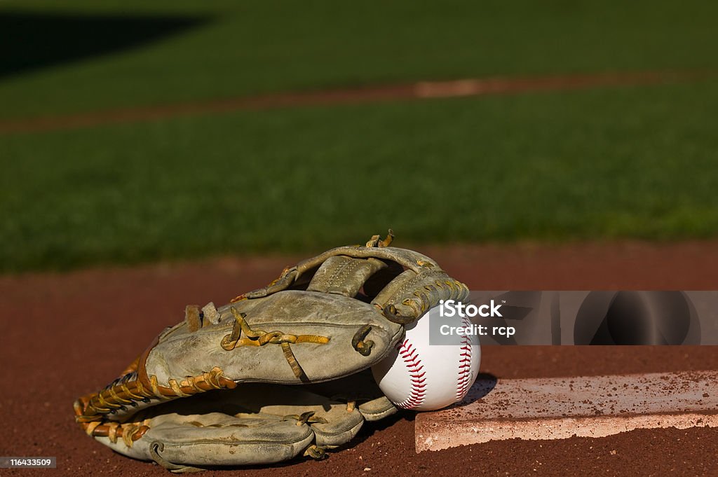 Baseball in glove on the field Baseball in a glove sitting on the pitchers mound of a diamond Baseball Spring Training Stock Photo