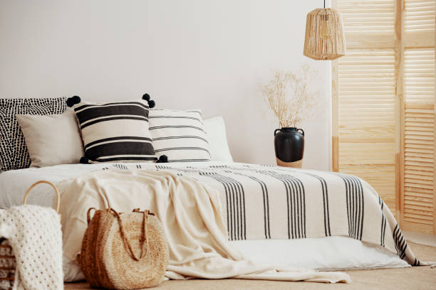 istock Wicker accents in white scandinavian bedroom interior 1164337858
