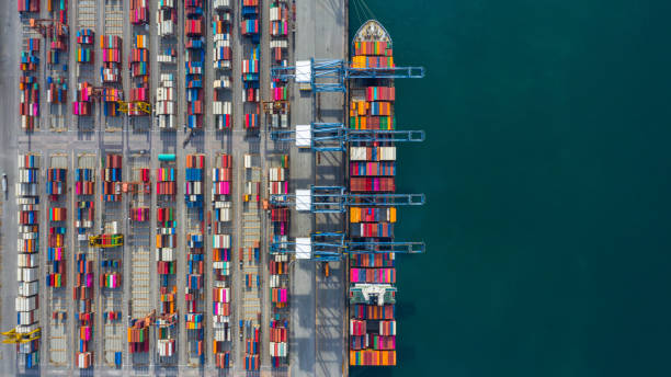 航空写真貨物船ターミナル、貨物船ターミナルの荷下ろしクレーン、コンテナとコンテナ船を備えた航空写真産業港。 - 港湾 ストックフォトと画像