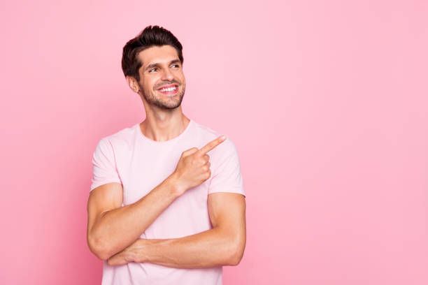 istock Portrait of his he nice attractive cheerful cheery confident content dreamy guy pointing forefinger aside promotion cool good surprise gift present ad isolated over pink pastel background 1164339480