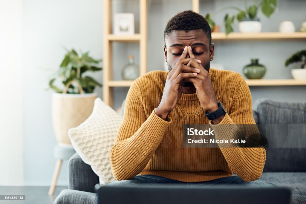 I need to find a way to cope with this stress Shot of a young man looking stressed out at home Men Stock Photo
