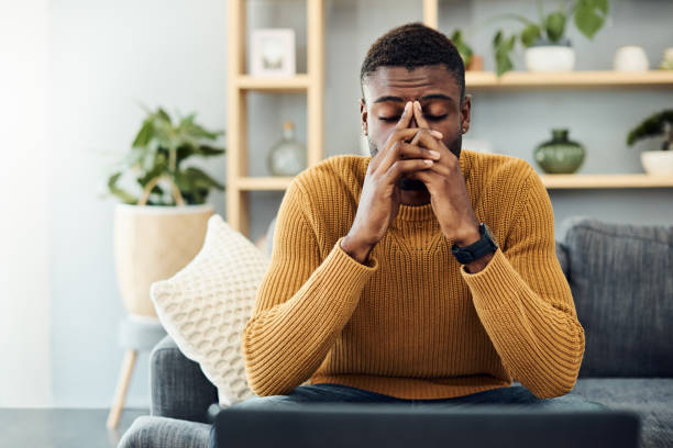 I need to find a way to cope with this stress Shot of a young man looking stressed out at home distraught stock pictures, royalty-free photos & images