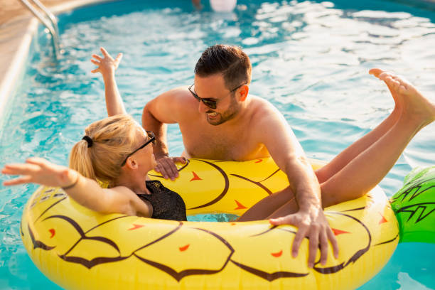 istock Couple having fun with the floating matress 1164339528