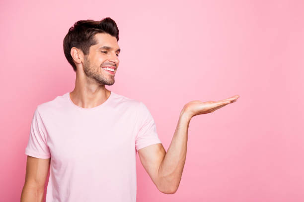 istock Portrait of his he nice attractive cheerful confident content guy holding copy empty blank space place good surprise gift present ad advert isolated over pink pastel background 1164340670