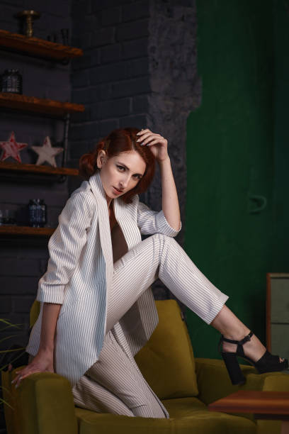 istock Pretty redhead thin young woman in white unbuttoned pant suit 1164341298