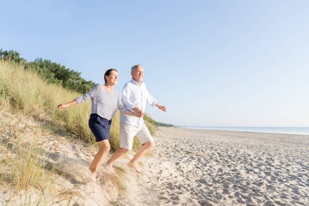 Happy senior couple at beach Happy senior couple at beach baltic sea people stock pictures, royalty-free photos & images