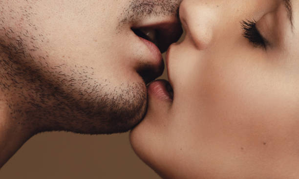 Romantic young couple kissing Close up of young man and woman kissing. Close up of a romantic young couple kissing with eyes closed. seduction stock pictures, royalty-free photos & images