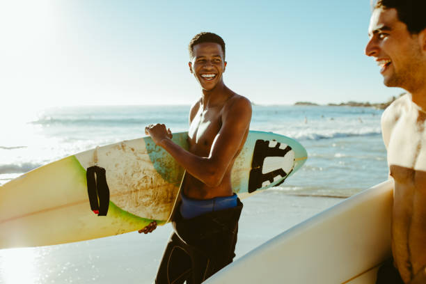 istock Two friends on surfing vacation at the sea 1164344636