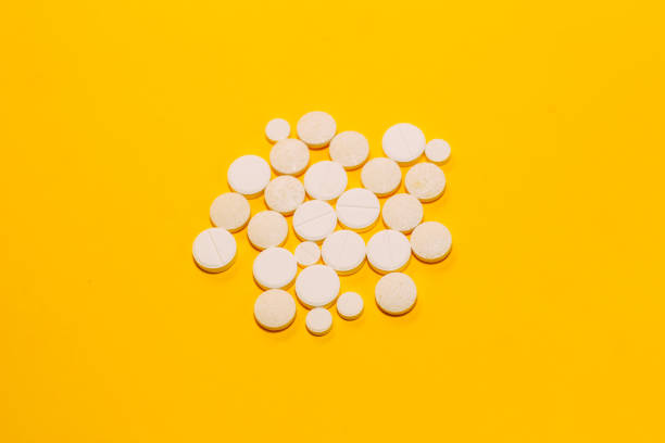 istock Different pills and vitamins are scattered on a yellow background. space for text 1164344822