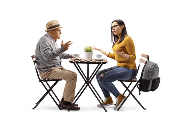 テーブルに座って年配の男と口論するカフェで怒っている女子学生 - talking chair two people sitting ストックフォトと画像