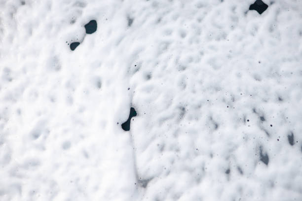 Washing car with soap. Close up of foam on windshield. Open car wash.