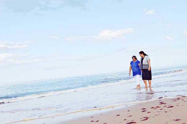 istock Mother daughter duo taking a walk at a beach on a bright sunny summer day 1164350656