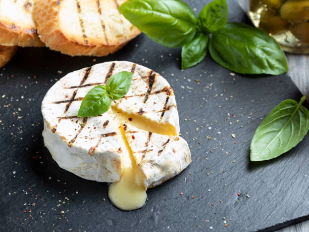 grill serowy camembert, na czarnym kamiennym tle - camembert zdjęcia i obrazy z banku zdjęć