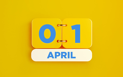 Yellow calendar on yellow background. April 1 writes on the calendar. Horizontal composition with copy space. Top view.