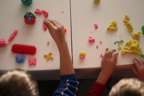 child's hand holding small play-doh house stock photo - playdoh imagens e fotografias de stock