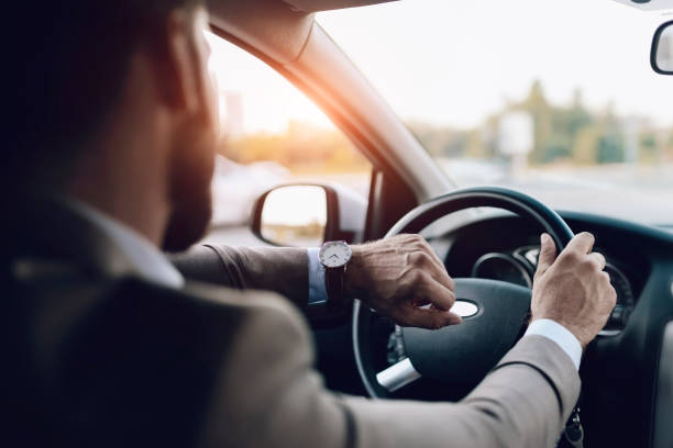 istock Businessman is Looking at Watch in His Car 1164361392