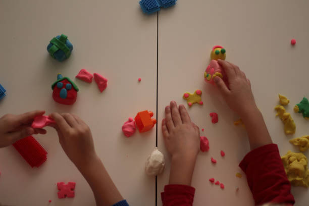 child's hand holding small play-doh house stock photo - playdoh imagens e fotografias de stock