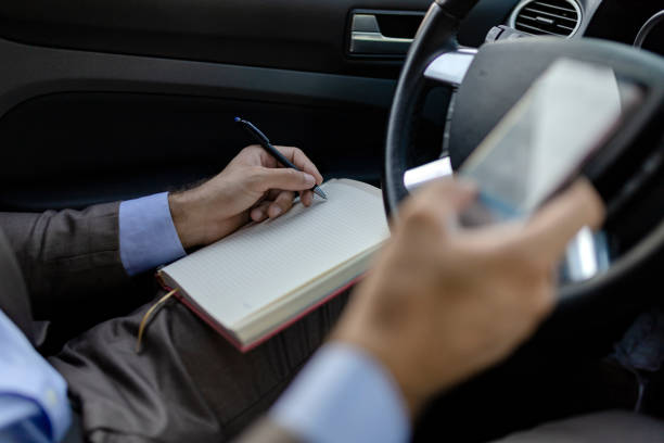 istock Businessman Writing Some Notes in the Car 1164361612