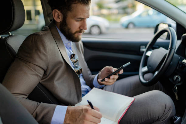 istock Business Man Writing Some Notes in the Car 1164361669