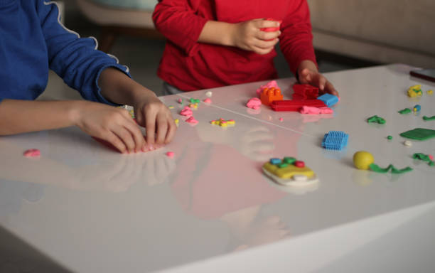 child's hand holding small play-doh house stock photo - playdoh imagens e fotografias de stock