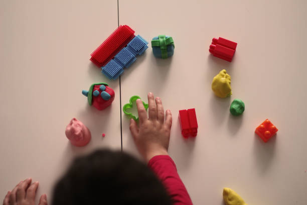 child's hand holding small play-doh house stock photo - playdoh imagens e fotografias de stock