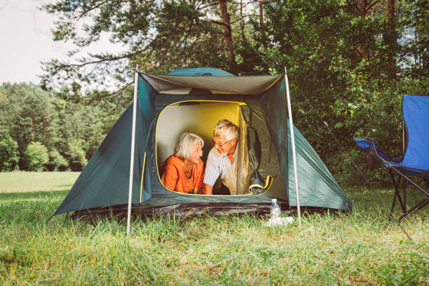 istock Senior couple having fun in front of tent at camping 1164362728