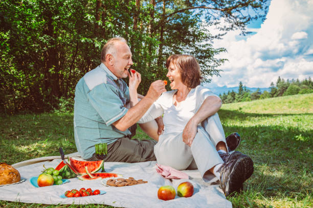 istock Senior couple having picnic on meadow 1164362832