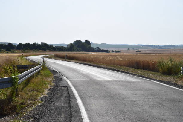 istock road through harvested grain field 1164362860