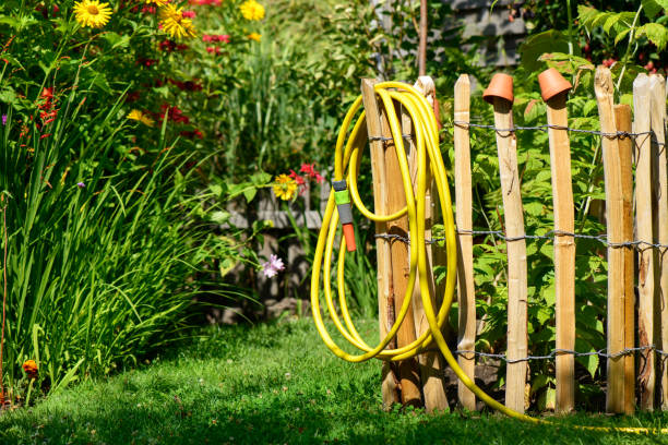 water sprays from a leaky garden faucet hooked to a hose.  Some of the spray is blurred into a stream, others are captured as droplets