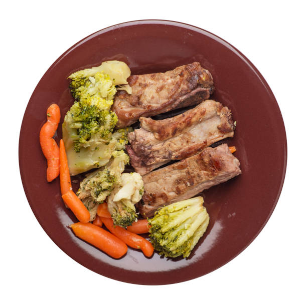 istock grilled pork ribs with broccoli cabbage, carrots and garlic on a plate. fried   ribs with vegetables on a white background. hearty rustic food top view 1164364763
