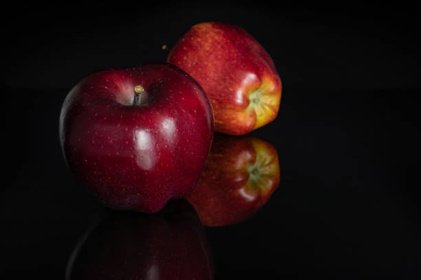 Red apple isolated on black mirror. High resolution photo. Full depth of field.