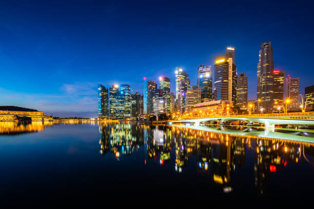 istock Singapore skyscraper building in downtown district with water reflection at Marina Bay in night, Singapore. 1164365581