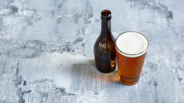 istock Glass of light beer on white stone background 1164365714