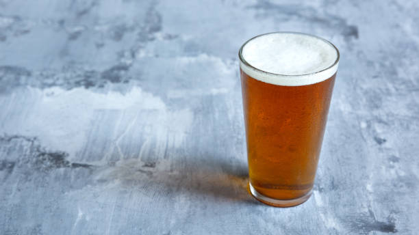 istock Glass of light beer on white stone background 1164365721