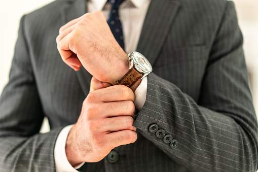 Businessman checking the time on his wristwatch, unrecognizable person