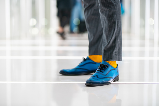 Blue leather oxford shoes on unrecognizable man, with yellow socks